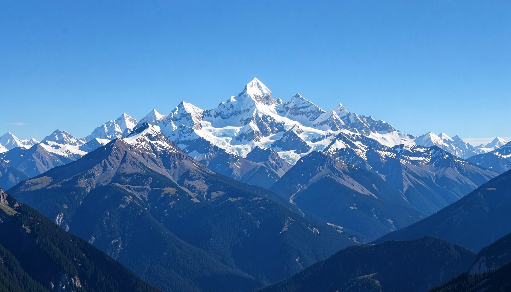 Panoramic banner of Banff's snow-capped mountain peaks against a clear blue sky